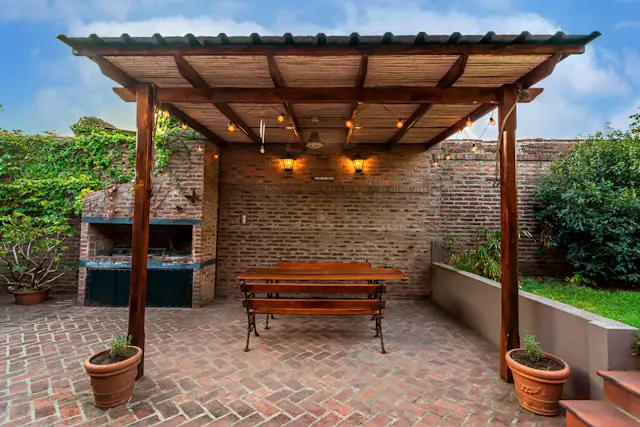 a brick backyard patio area and grill